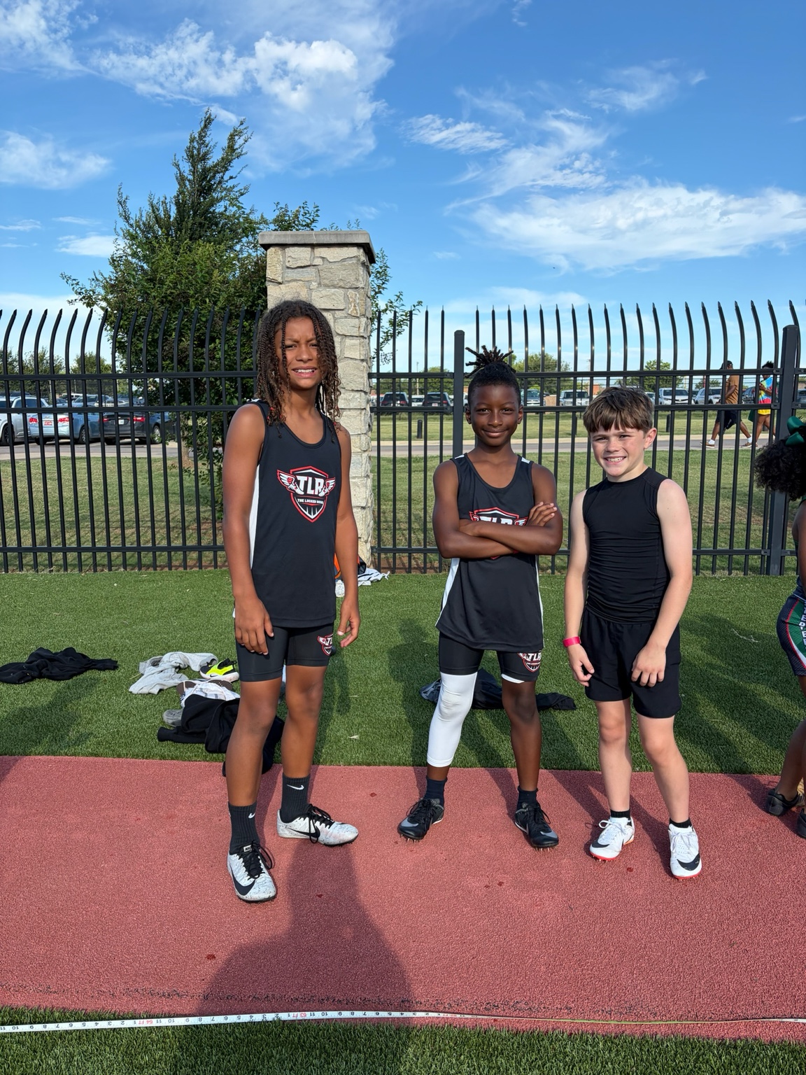 The Locker Room athletes together beside the track